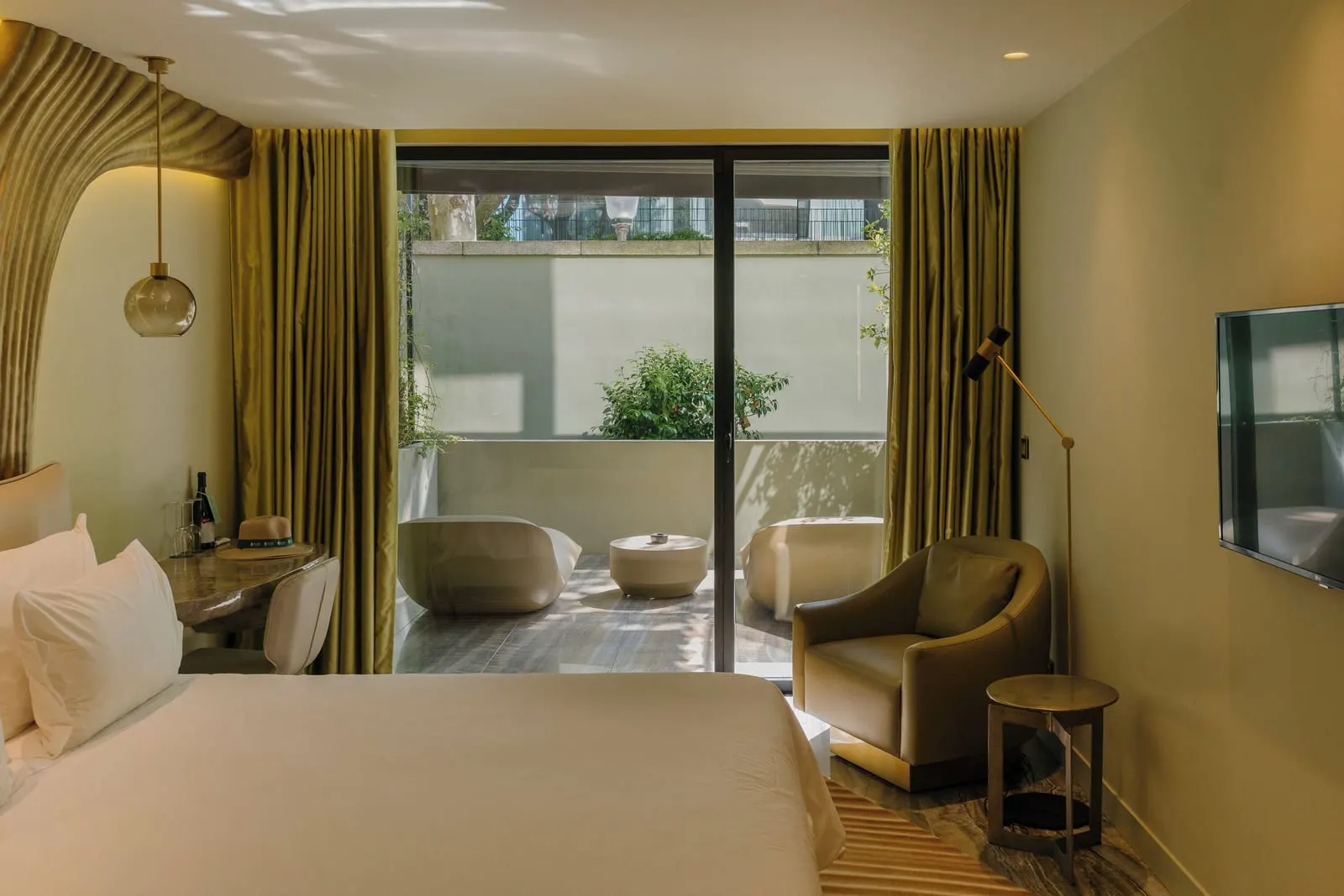 Onice Terrace Room at Vila Foz: the bed, a desk, an armchair and glass doors to a terrace with two day beds