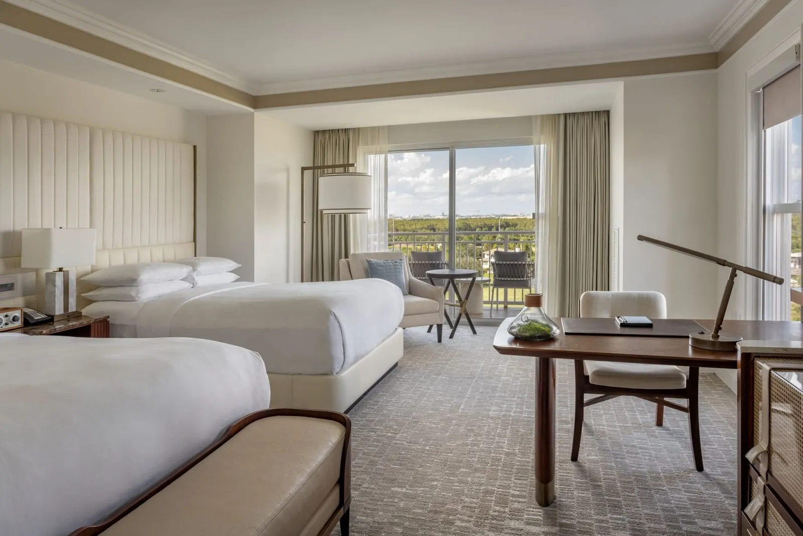The Ritz-Carlton Club room at The Ritz-Carlton Orlando, Grande Lakes: two queen beds, a writing desk and an armchair by the sliding door onto the balcony