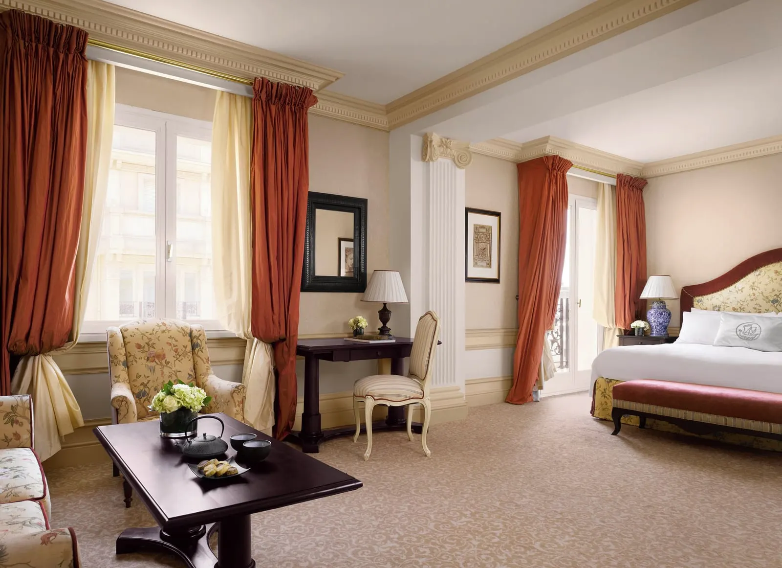 Deluxe Junior Suite at Hôtel Métropole Monte-Carlo: an armchair and coffee table in the sitting area, the bed beyond