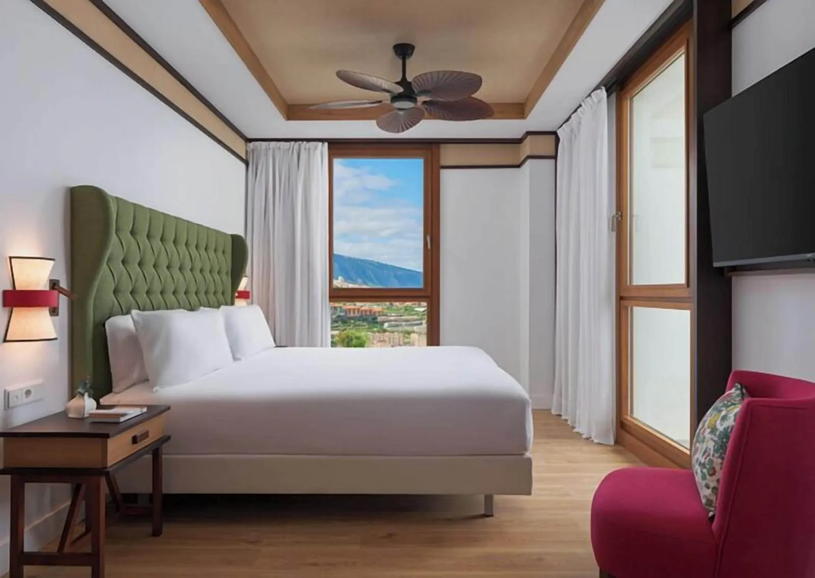 1 Bedroom Suite with Balcony Ocean View at Gran Hotel Taoro: a bed with a green headboard and a red armchair