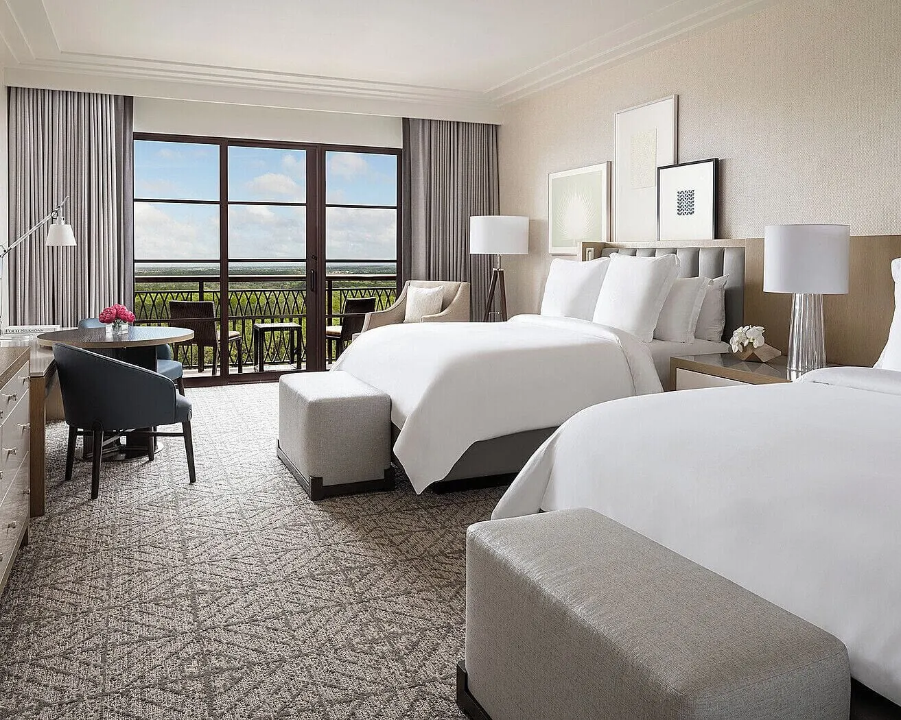 Park View Room im Four Seasons Resort Orlando at Walt Disney World Resort: zwei Queensize-Betten, ein runder Tisch mit zwei Stühlen, ein Sessel und Glastüren zur Terrasse