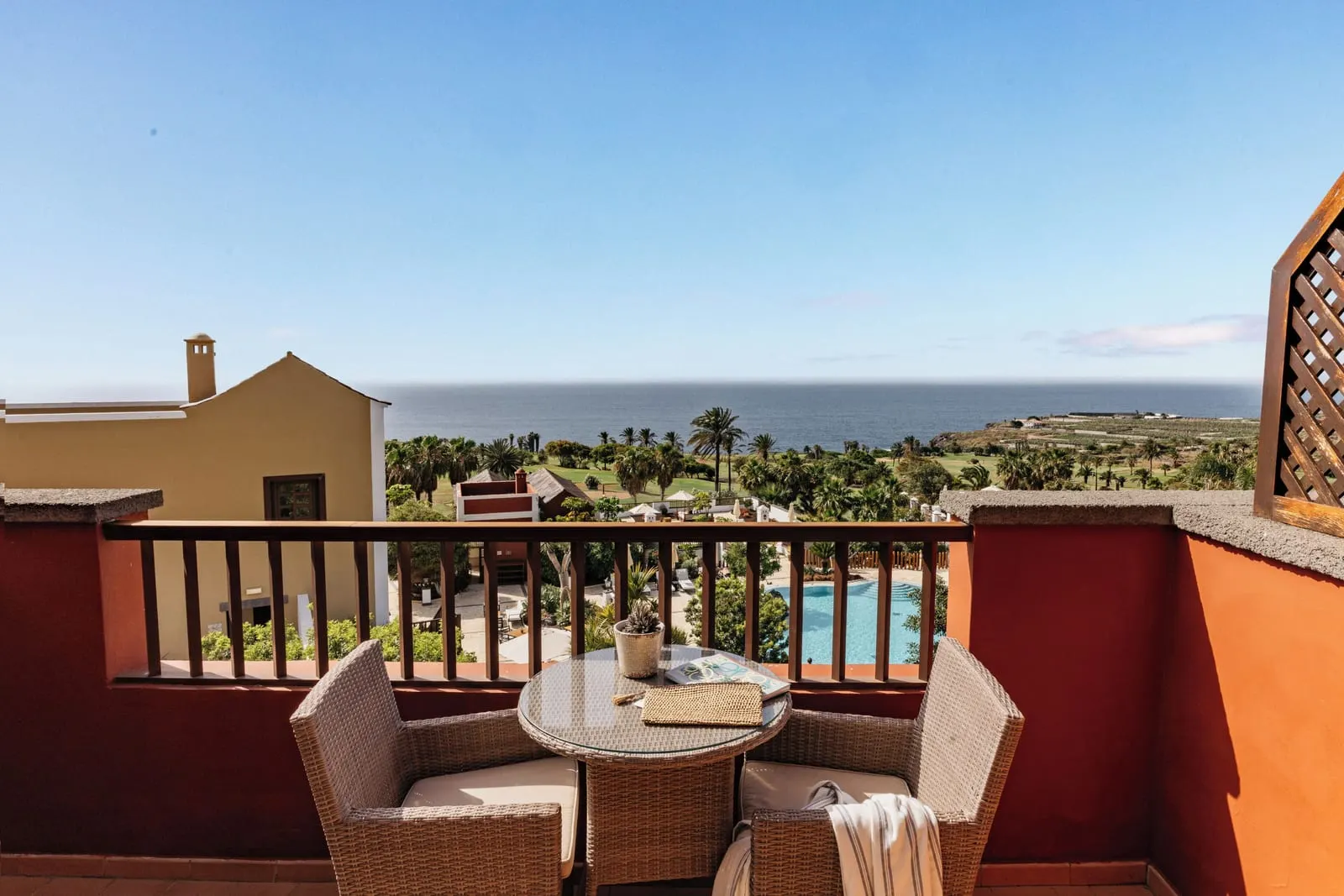 Singular Junior Suite Sea View with Panoramic Terrace at Hacienda del Conde: wicker chairs above palms, a pool and the sea