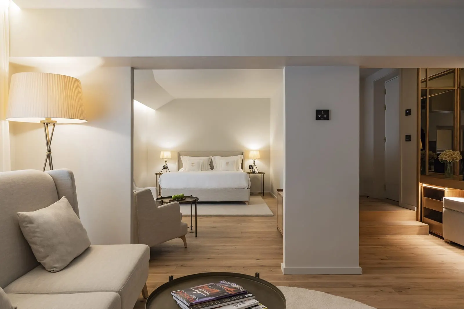 King 1 Bedroom Suite at Casa da Companhia: the sitting area with a sofa and an armchair, and the bedroom beyond