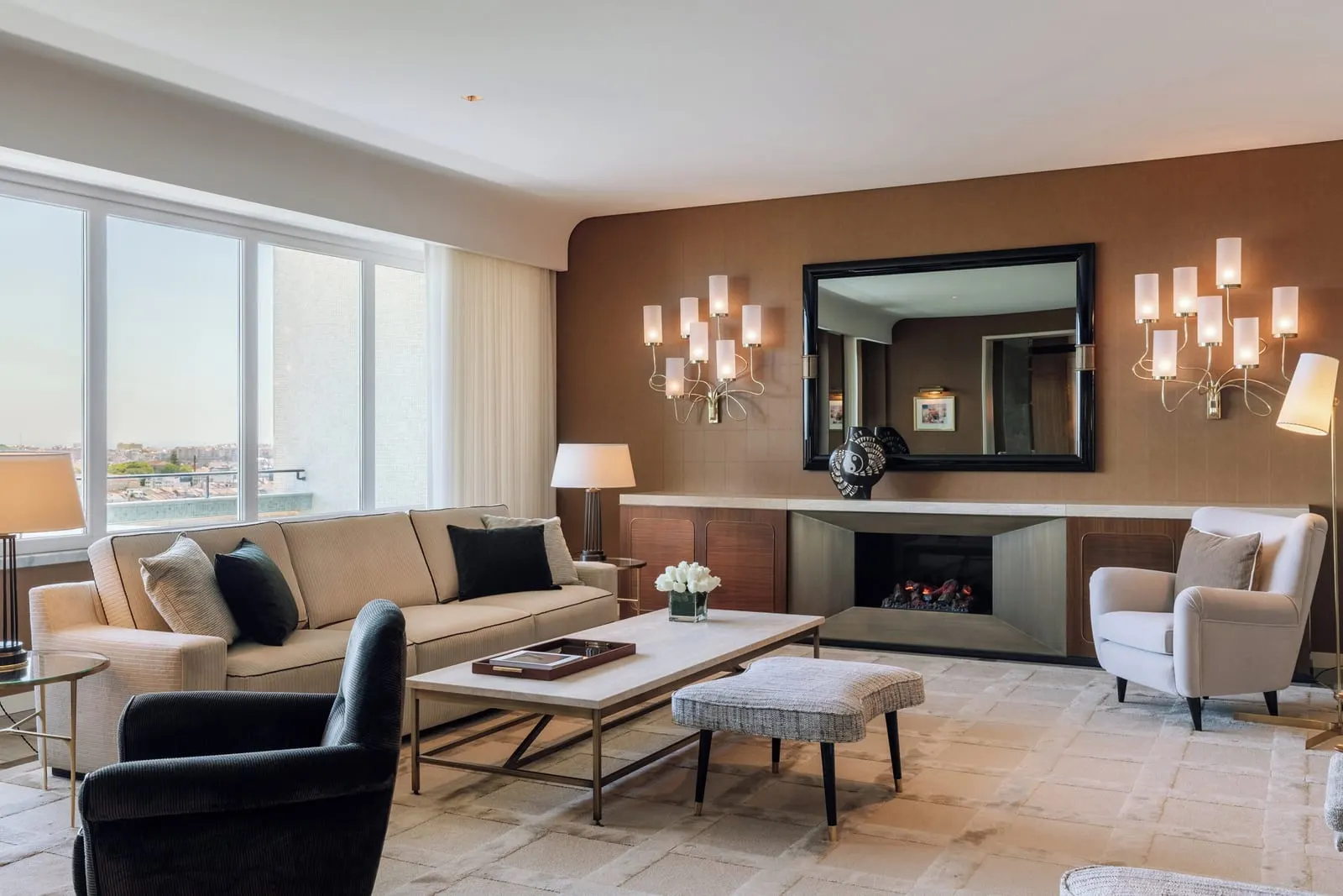 Pedro Leitão Suite at Four Seasons Ritz Lisbon: the living room, with a sofa, armchairs and a fireplace below a mirror