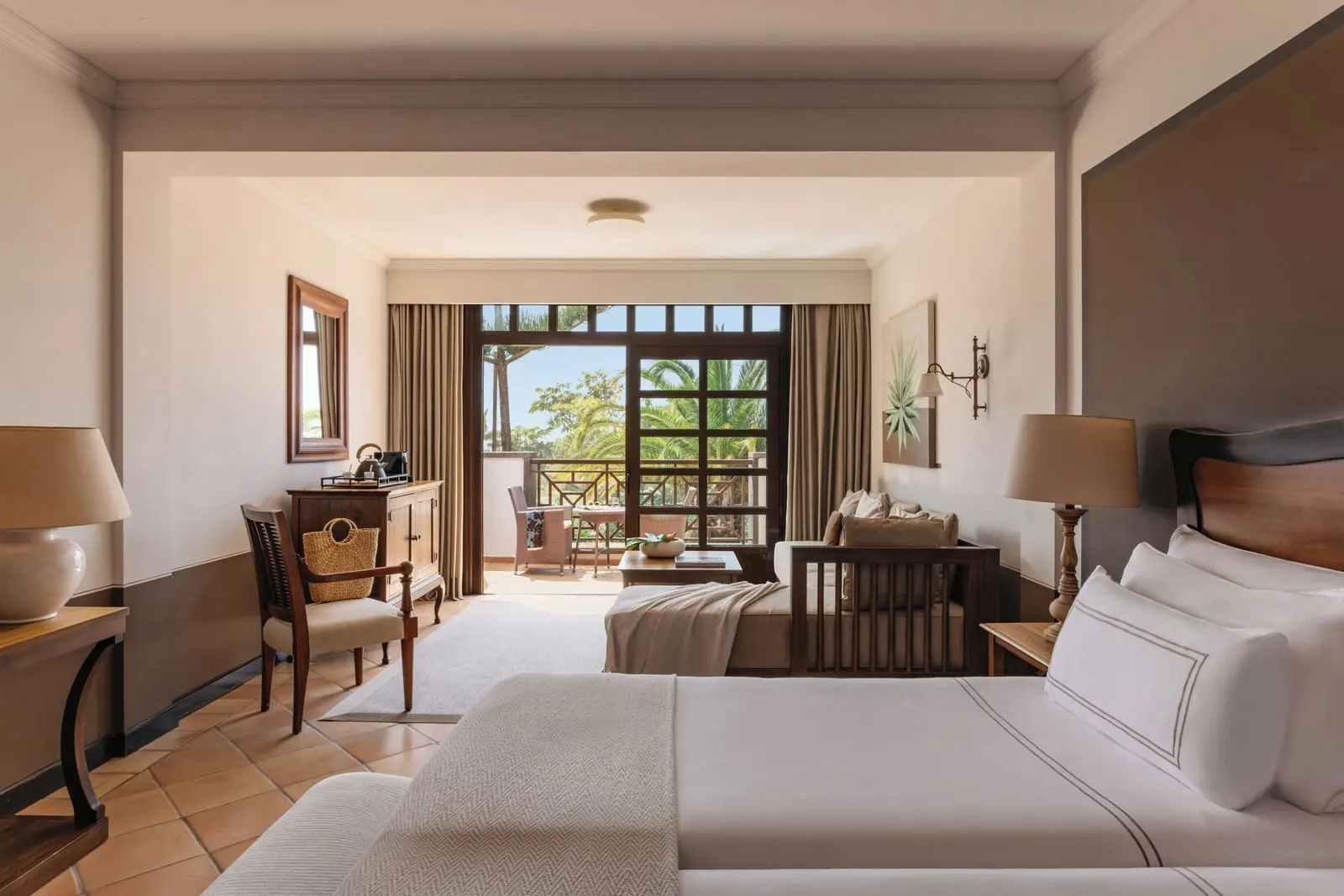 Singular Junior Suite Golf View at Hacienda del Conde: two beds, a desk and a sofa by doors to the balcony