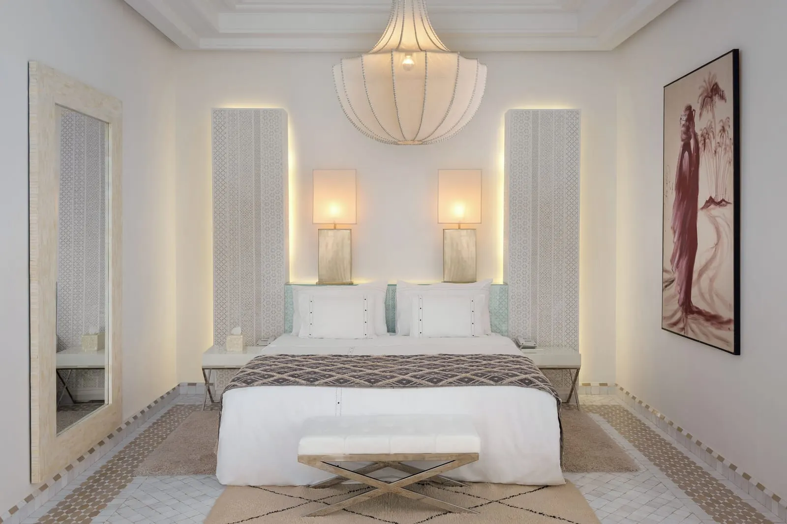 White Suite at Dar Rhizlane: a king-size bed in an all-white room under a large paper pendant lamp, with a long mirror and a bench at the foot
