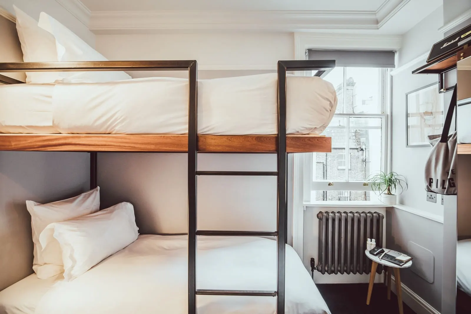 Bunk at The Pilgrm: two stacked single beds with a steel frame and ladder, beside a sash window