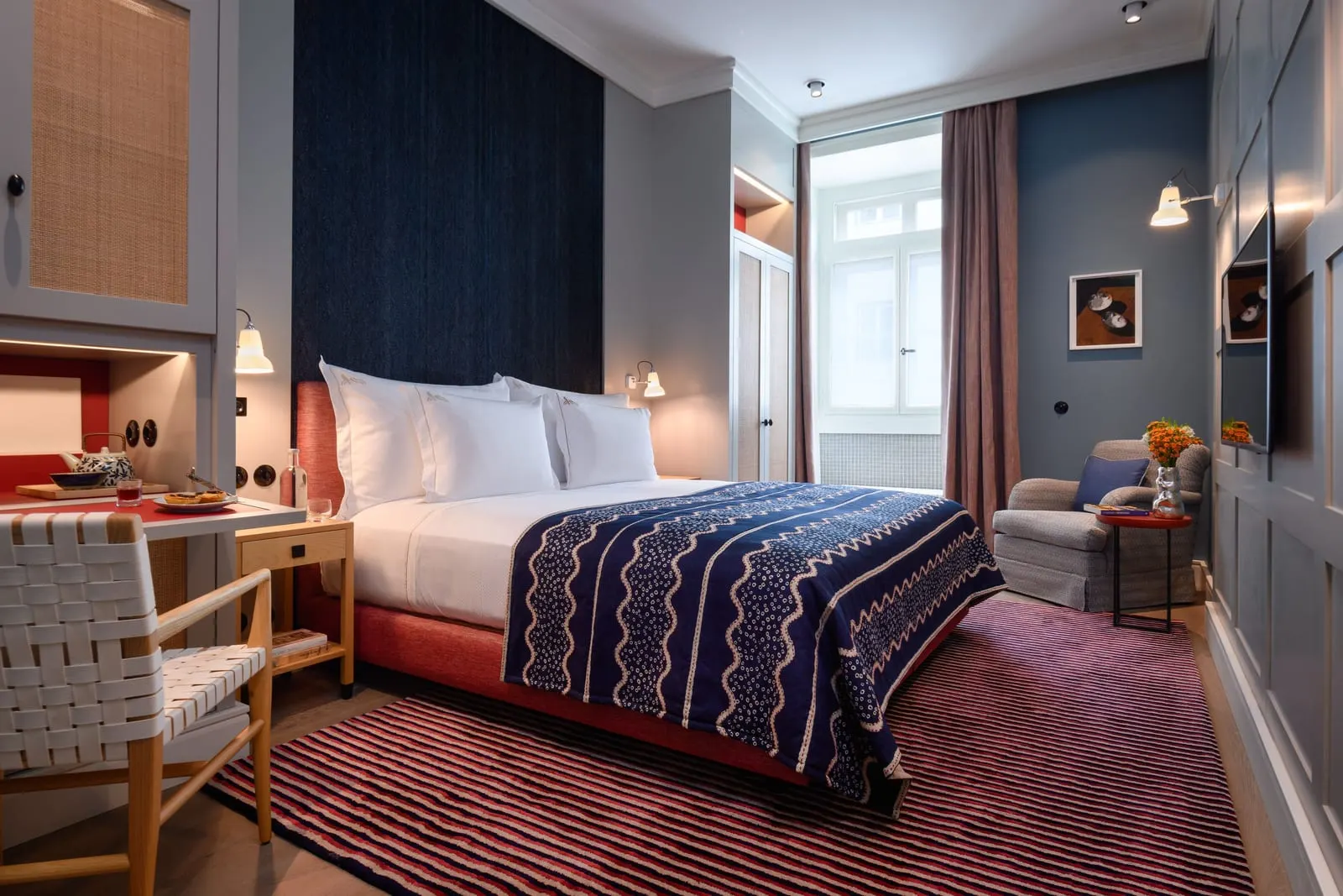 Classic Tejo room at Bairro Alto Hotel: a double bed with a navy throw, a desk, an armchair and a tall window