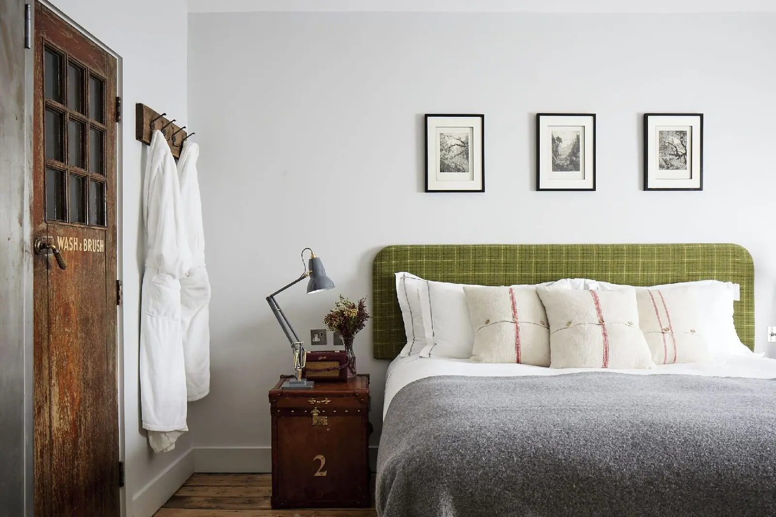 Medium Double or Twin at Artist Residence London: the bed with a green check headboard, three framed prints and robes