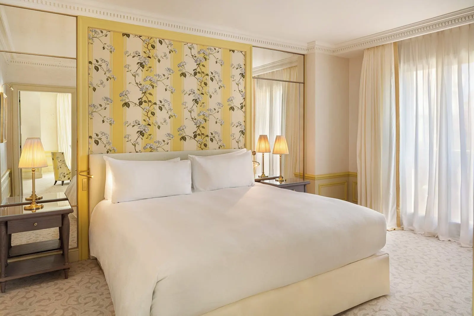 Deluxe Premium Suite at Hôtel Métropole Monte-Carlo: the bedroom with a yellow floral panel behind the bed