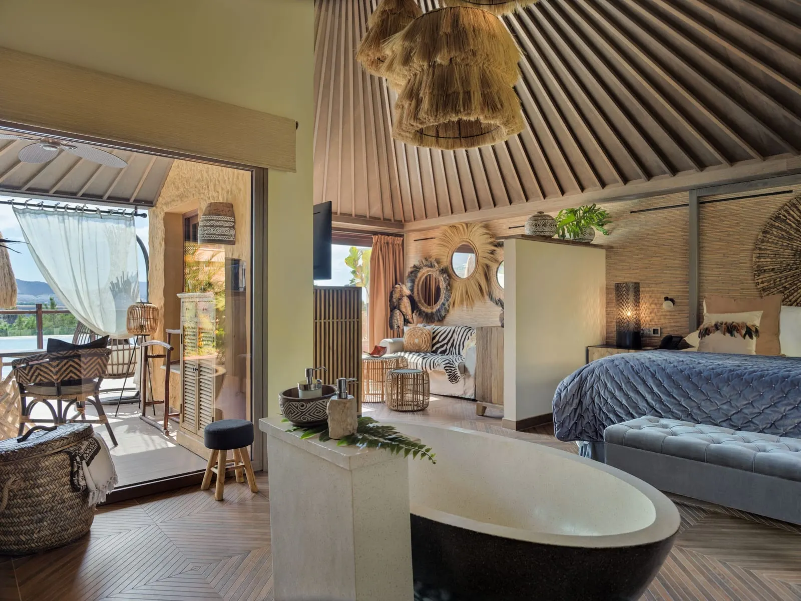 One-bedroom Lagoon Villa at Royal River: a freestanding bath, the bed and a sofa under a slatted timber ceiling