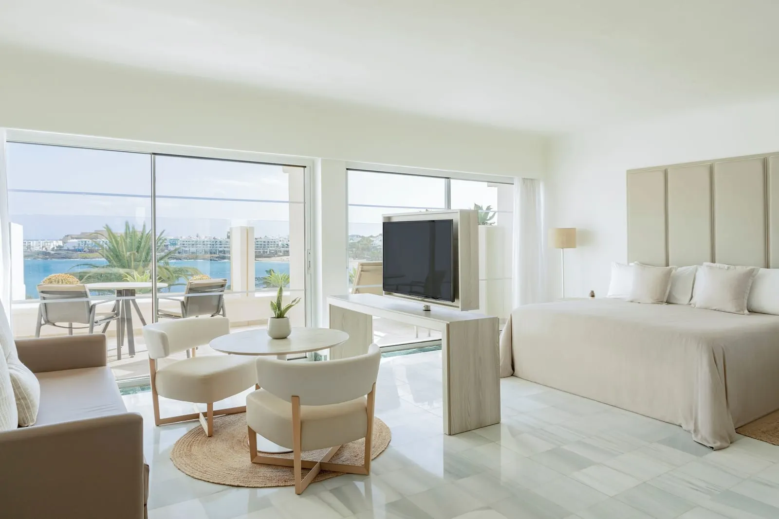 The Reserve Junior Suite Ocean Front at Paradisus Salinas Lanzarote: an open-plan bedroom and lounge with large windows towards the sea
