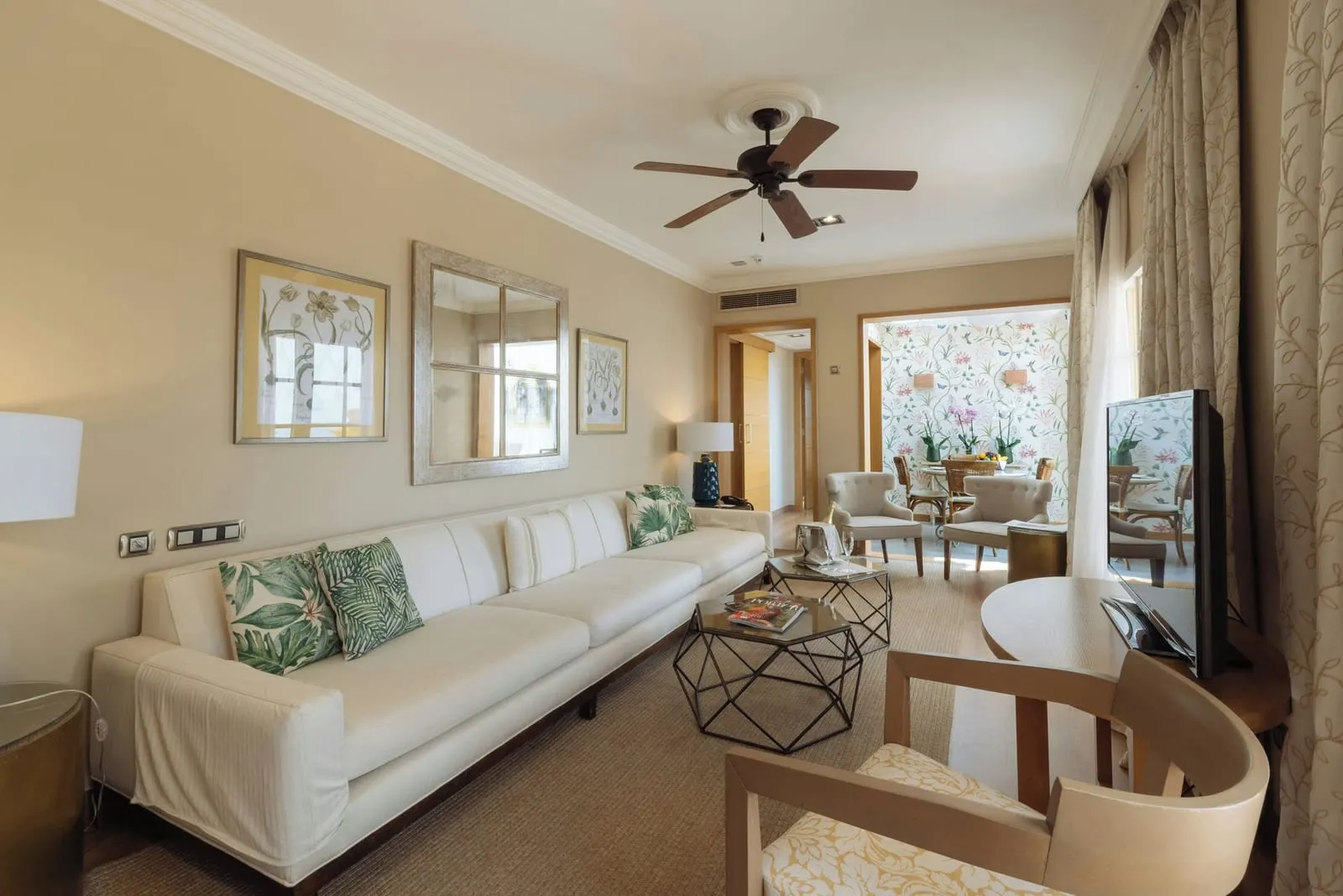Casas Ducales Presidential Suite at Bahía del Duque: the living room, with a long white sofa and the dining area beyond