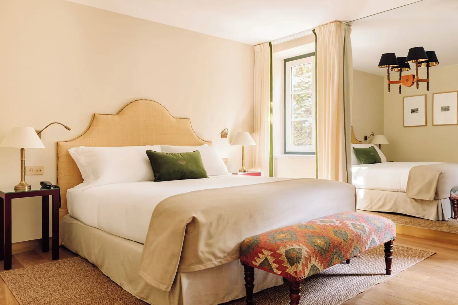 Deluxe Garden View room at Hotel das Amoreiras: the bed with a cane headboard and a patterned bench at its foot