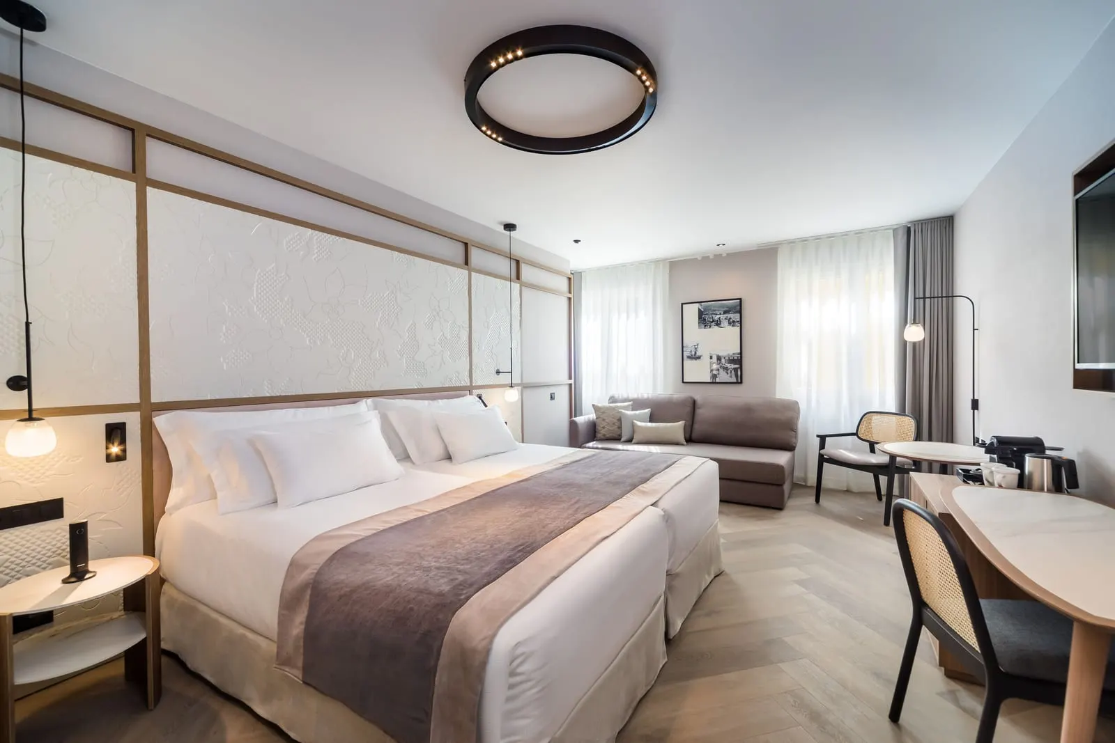 Junior Suite at Barceló Funchal Oldtown: two single beds made up together, a grey sofa bed under the windows and a desk with a coffee machine on the right