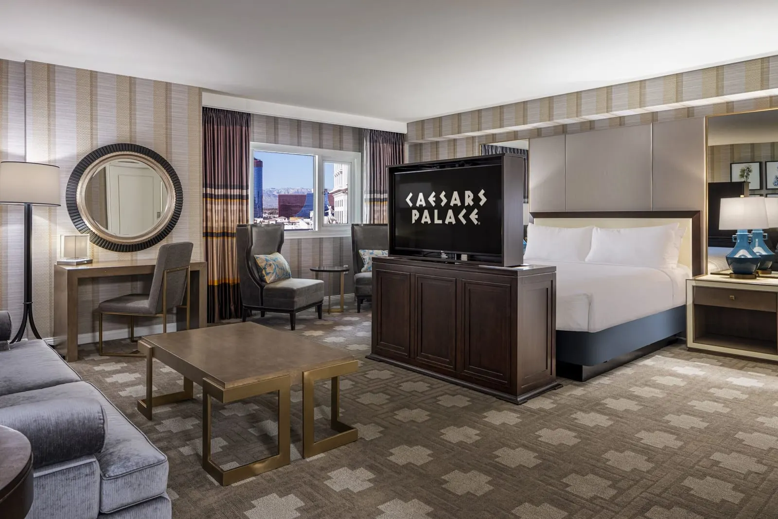 Julius Executive Studio Suite im Caesars Palace: ein offener Raum mit einem Kingsize-Bett, einem Fernsehschrank am Fußende, einem Schreibtisch, Sesseln und einem Couchtisch
