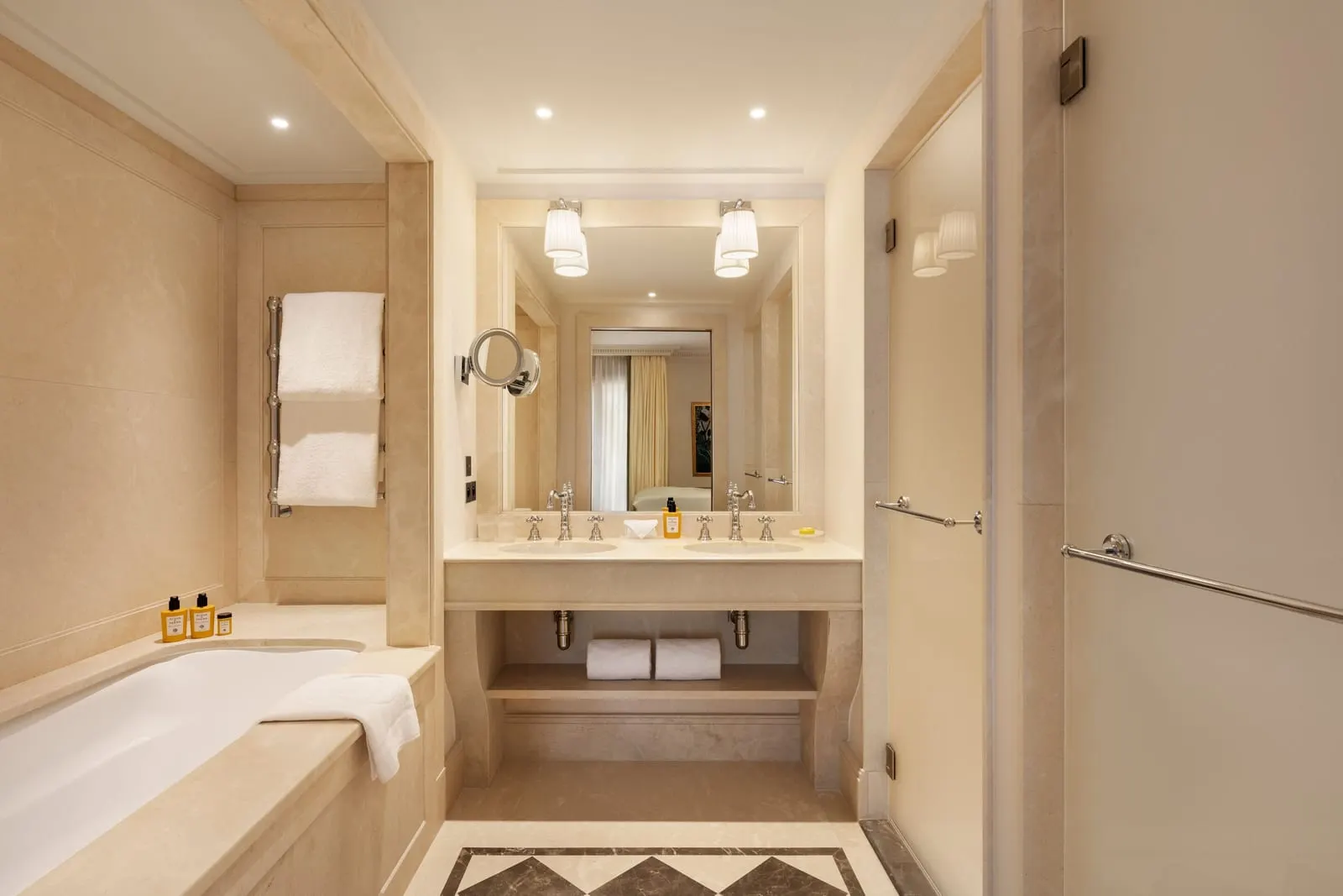 Prestige Room at Hôtel Métropole Monte-Carlo: the marble bathroom with a bathtub, a basin and a glass shower door