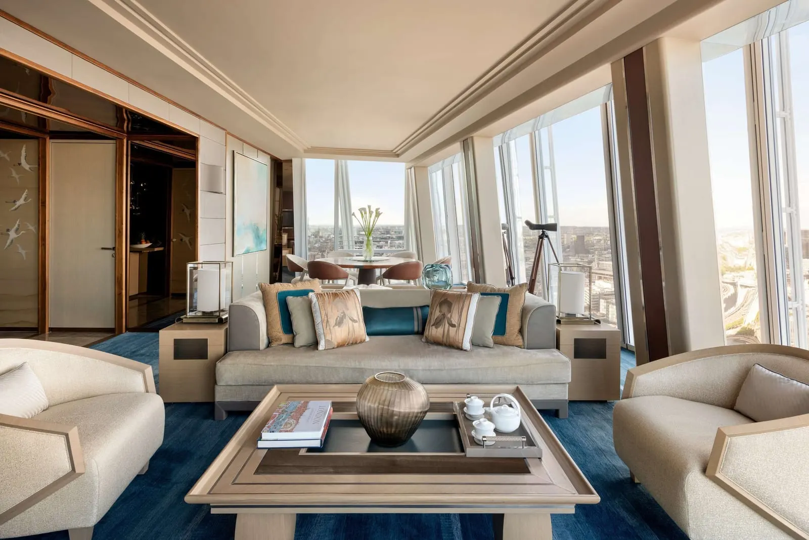 Westminster Suite at Shangri-La The Shard: the living room with sofas, armchairs and a telescope by the windows