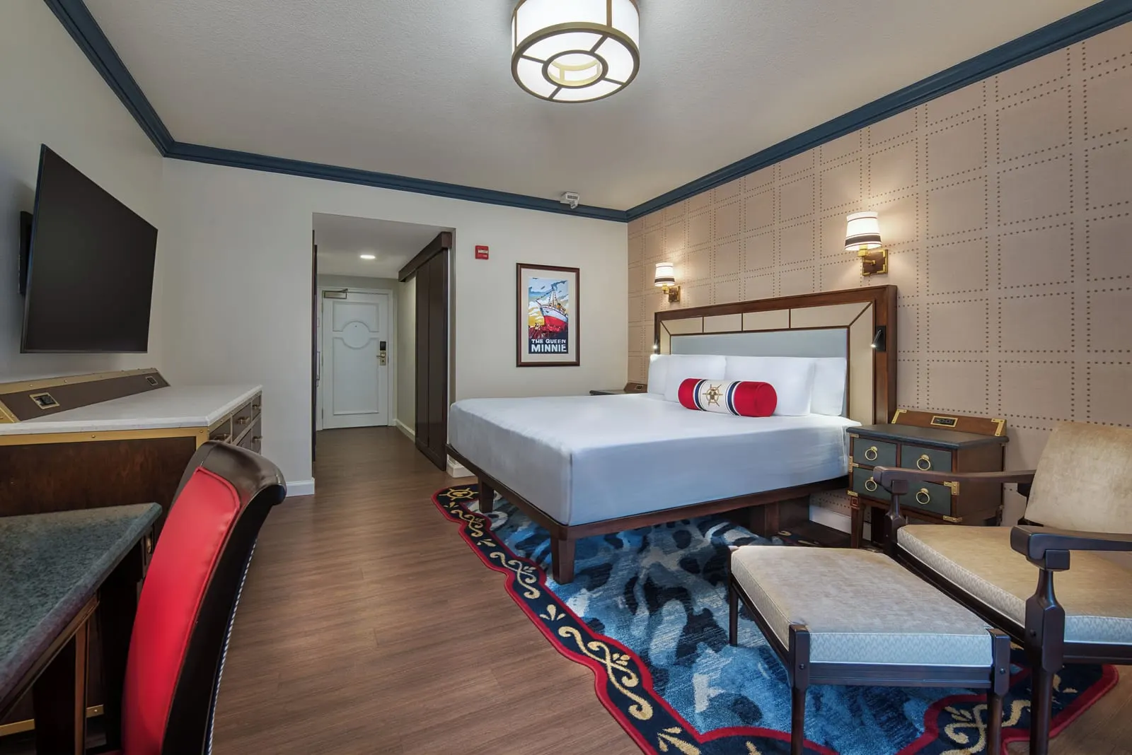 Resort View room im Disney's Yacht Club Resort: ein Kingsize-Bett, ein Sessel mit Fußhocker, ein Fernseher über der Kommode und der Flur zur Tür