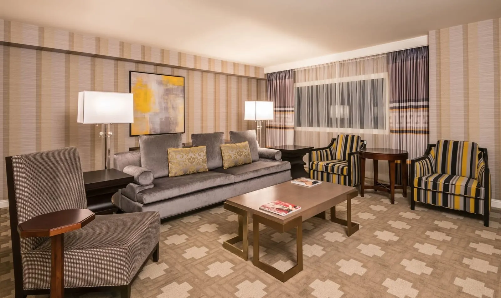 Julius Executive Suite im Caesars Palace: ein Wohnzimmer mit einem grauen Sofa, zwei gestreiften Sesseln, einem Couchtisch und einem breiten Fenster