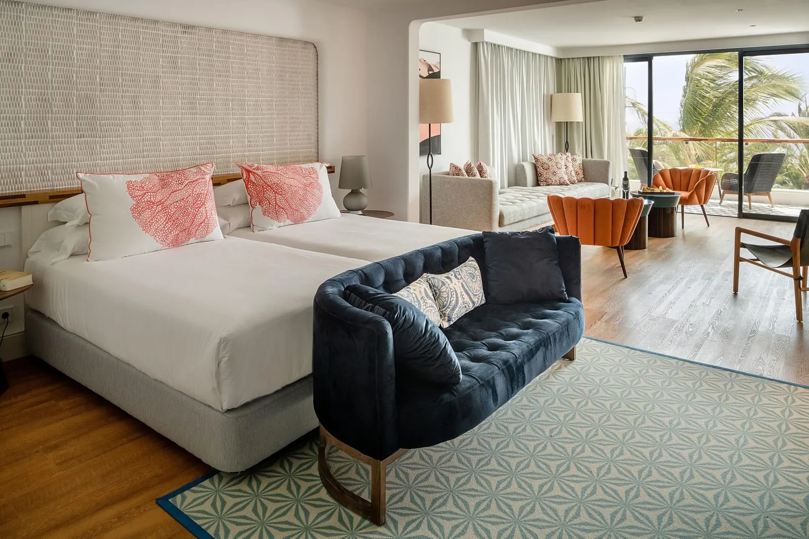 Suite Loft Sea View at Hotel Fariones: twin beds with a navy velvet sofa at the foot, and a seating area by the terrace behind