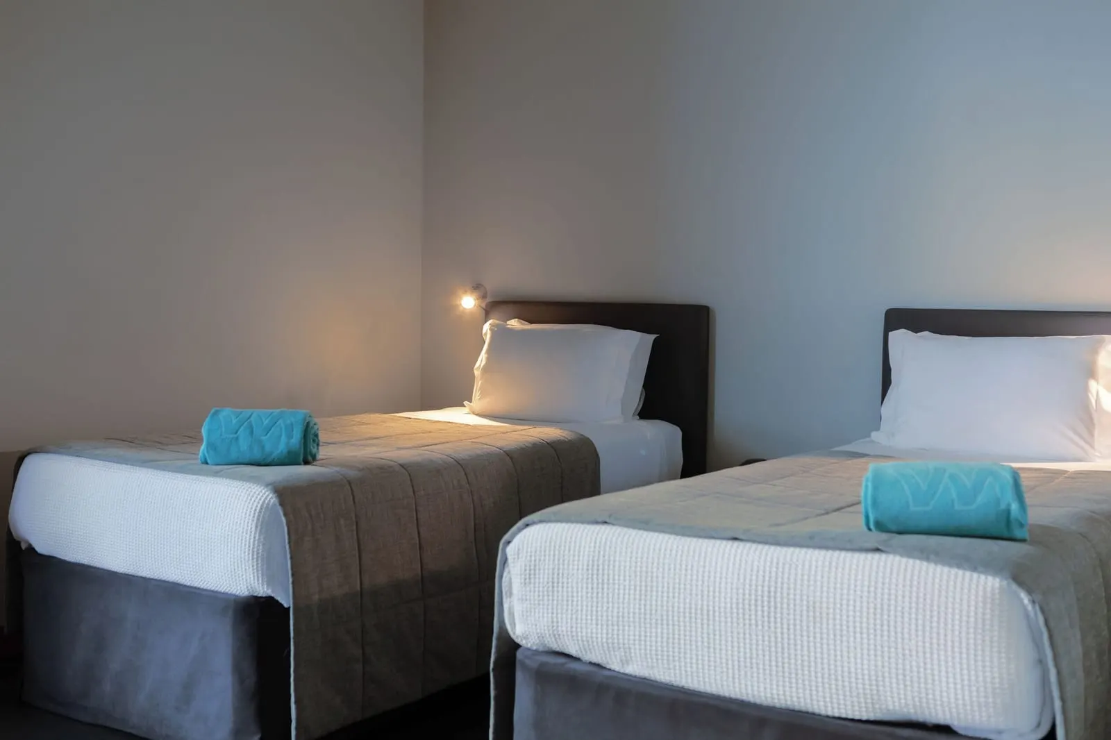 VidaMar Resort Hotel Madeira Premium Family Sea View Room：2つ目の寝室にある、丸めたターコイズ色のタオルを置いた2台のシングルベッド