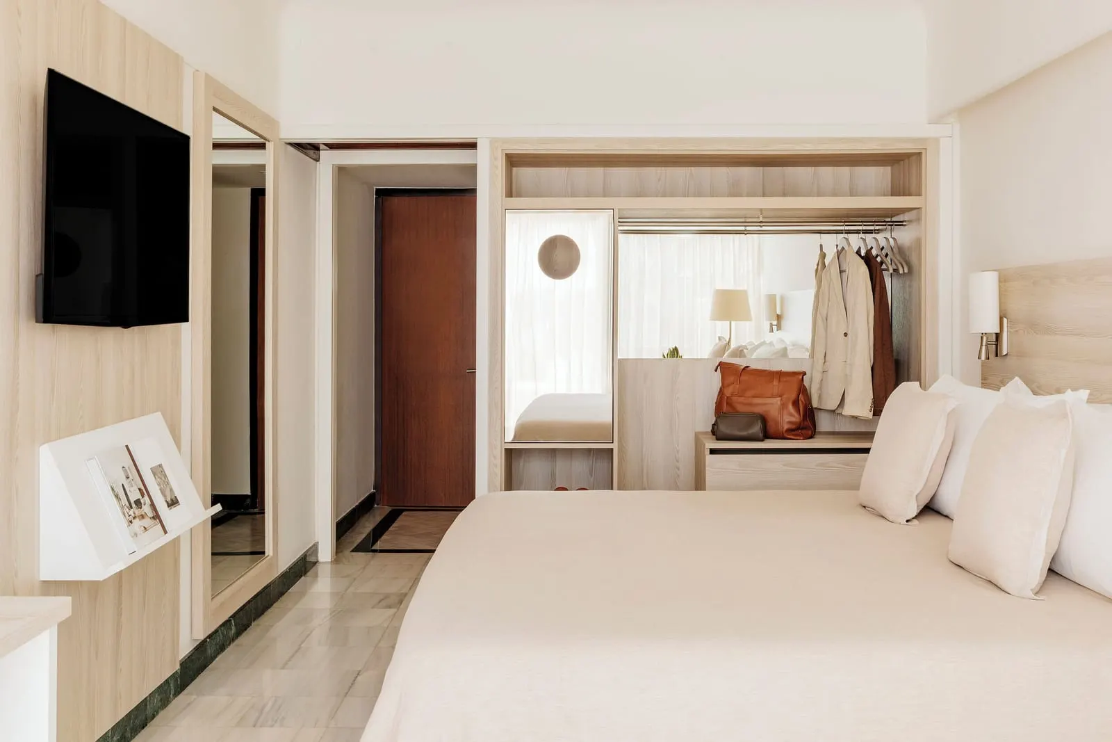 The Reserve Premium Ocean Front at Paradisus Salinas Lanzarote: a bed with a wardrobe and a wall-mounted television beside the room entrance