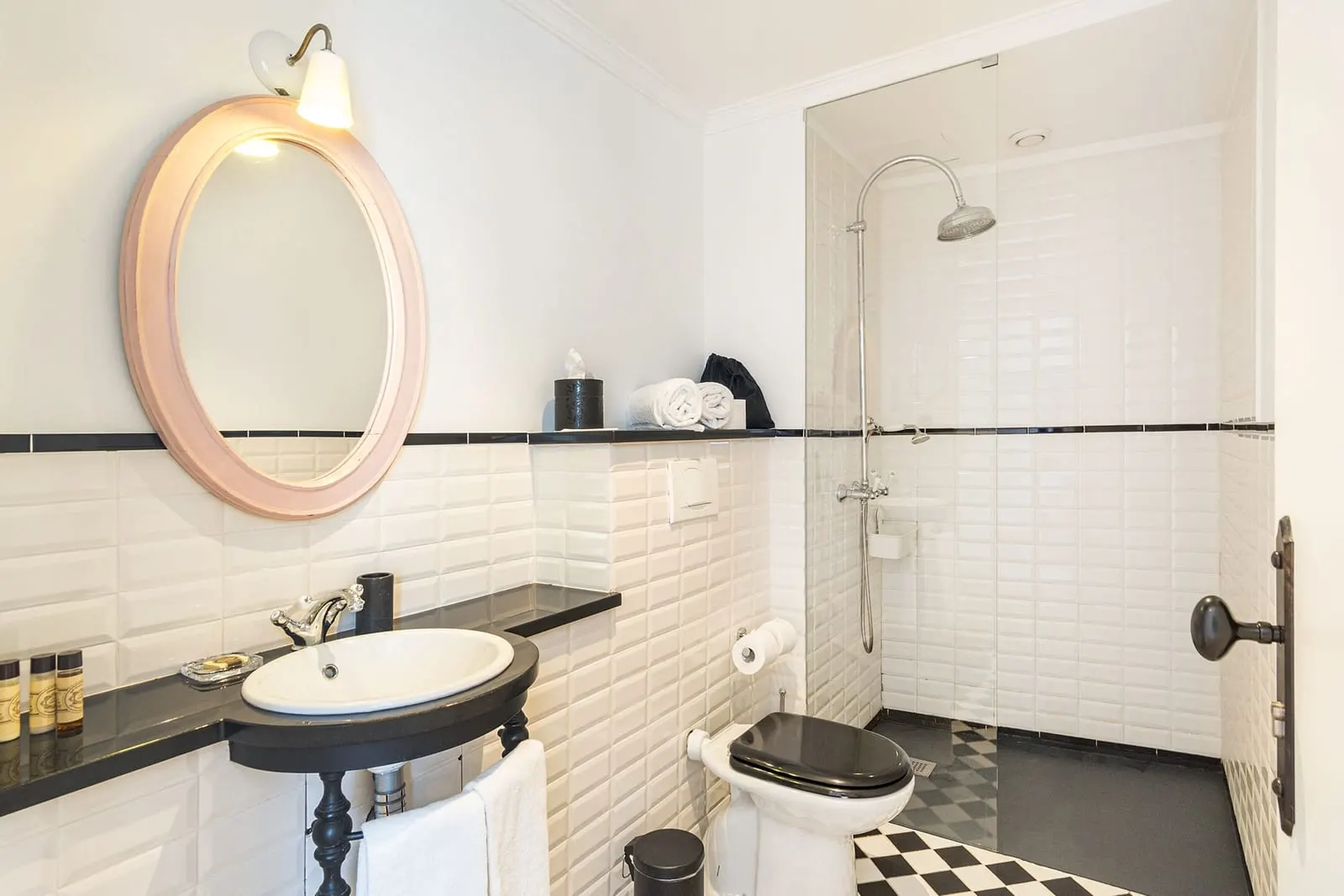 Superior Room with River View bathroom at 1872 River House: a walk-in shower, an oval mirror and a basin on a black stand