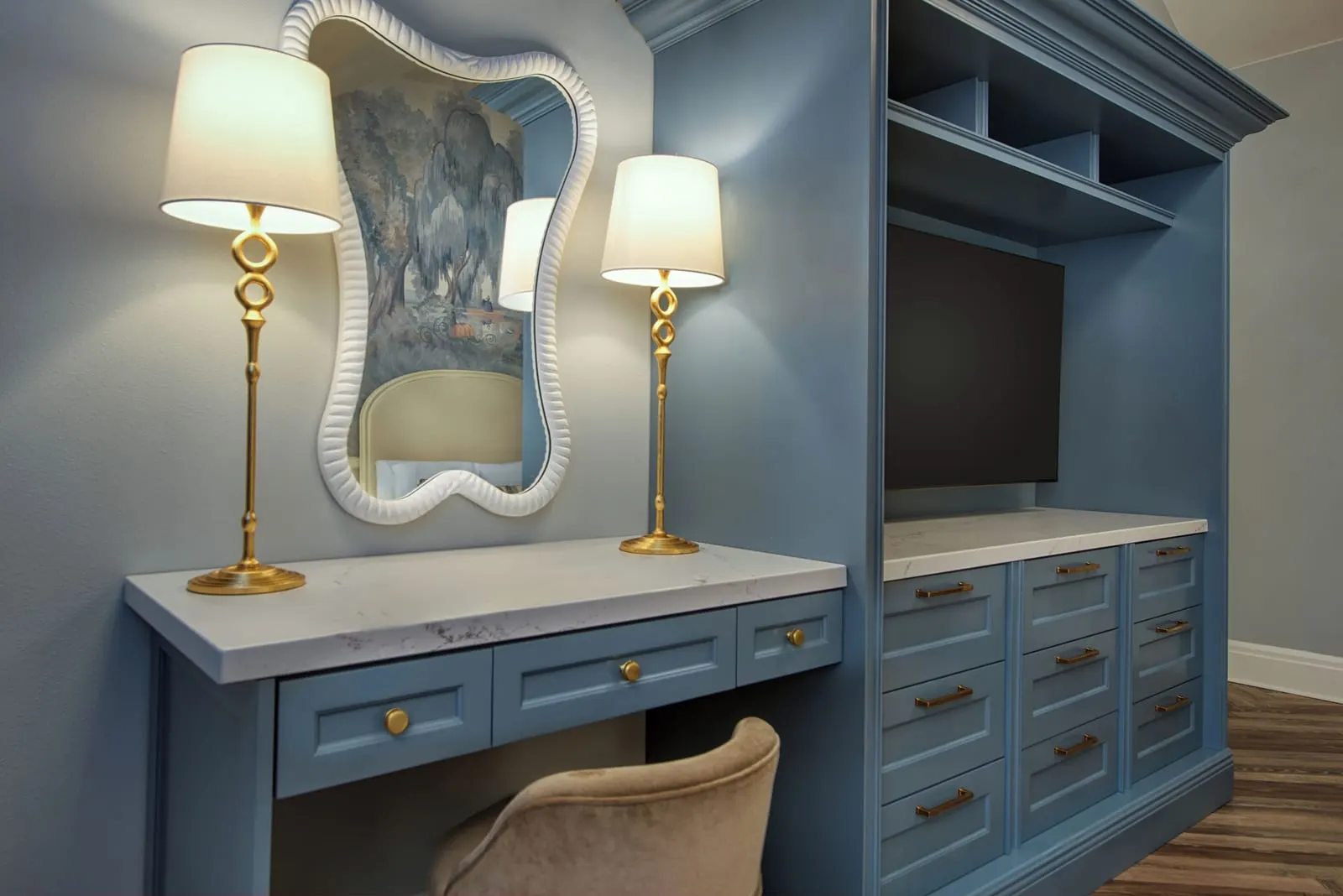 Water View room at Disney's Grand Floridian Resort & Spa: a blue dressing table with a wavy white mirror and two gold lamps beside a built-in blue cabinet with a television and drawers