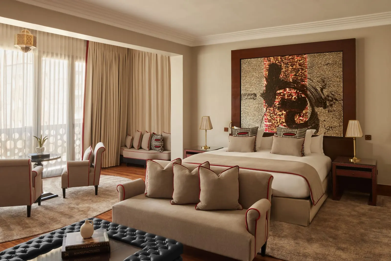 Deluxe Junior Suite at Nobu Hotel Marrakech: a king bed and a lounge with a sofa, armchairs and a daybed beside tall curtained windows