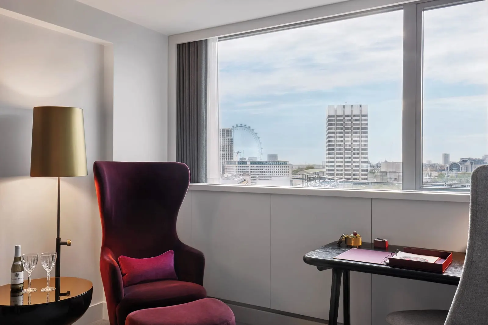 Superior Room at Sea Containers London: a wing chair, a desk and a window with the London Eye in the distance