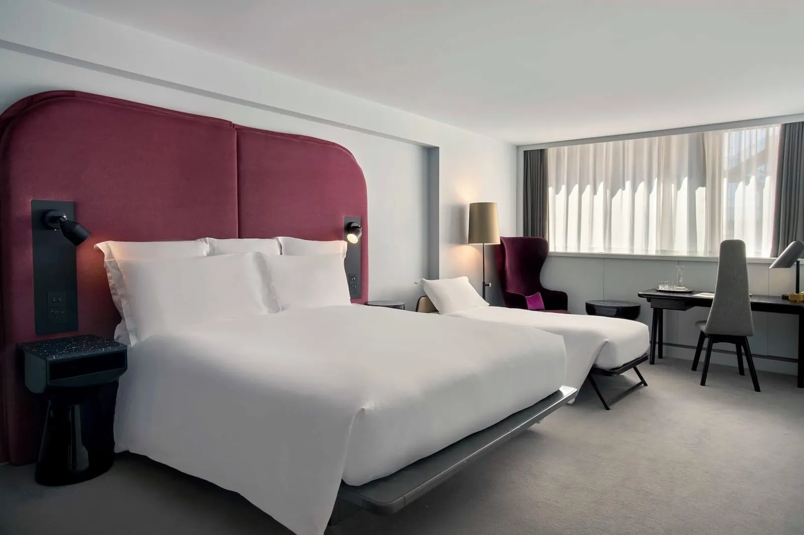 Studio Room at Sea Containers London: the bed with a red headboard, a narrower second bed by the window and a desk