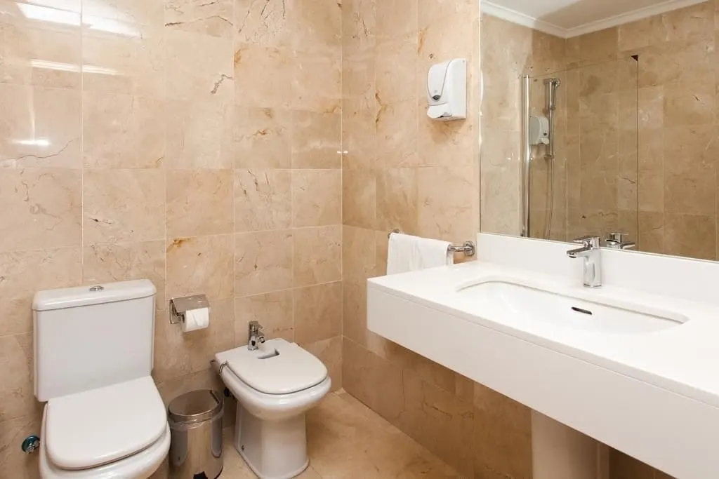 Sea View Double Room at El Mirador de Fuerteventura: a marble-tiled bathroom with a wide basin, toilet, bidet and glass-screened shower