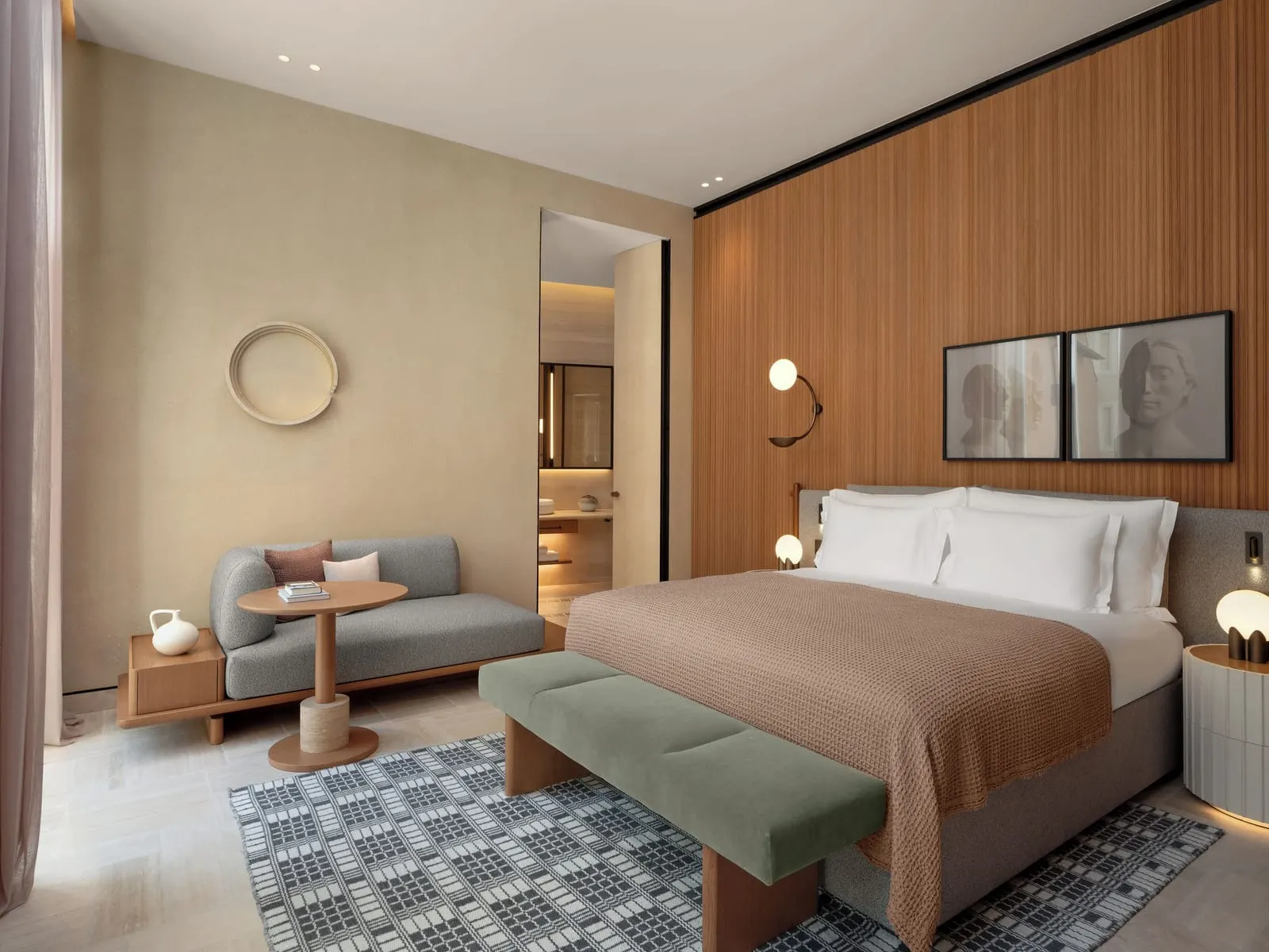 Salviati Suite at Six Senses Rome: the bed with a green bench, a small sofa and a doorway to the bathroom