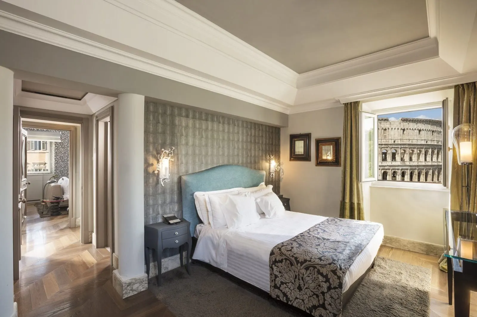 Family Suite at Palazzo Manfredi: a double bed, the Colosseum in the window and an open doorway to the next room