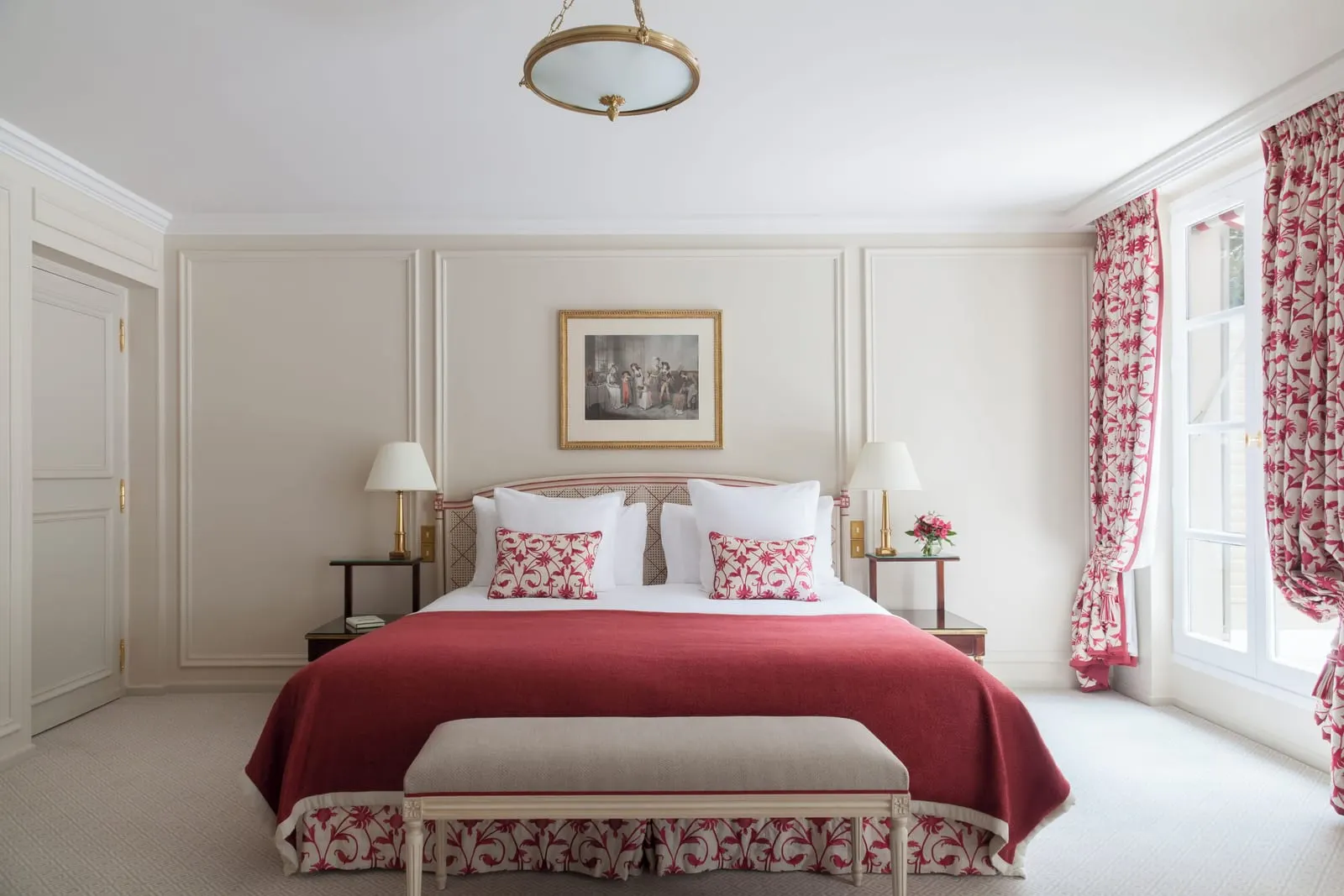 Deluxe Room with balcony at Le Bristol Paris: the king bed seen straight on, with a cane headboard, a bench at its foot and cream panelled walls