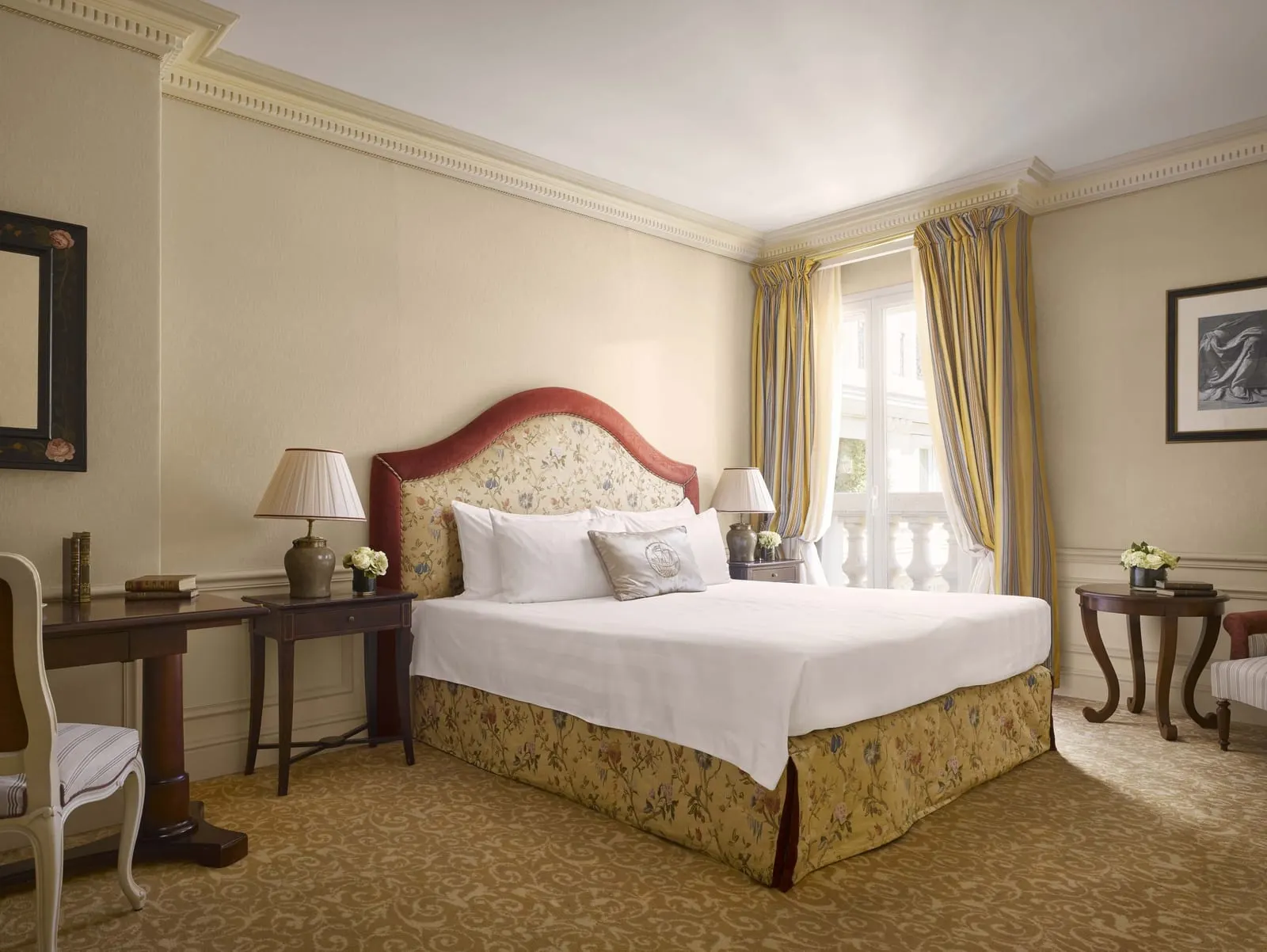 Deluxe Room at Hôtel Métropole Monte-Carlo: the bed with a floral headboard, a desk and a window with a stone balustrade
