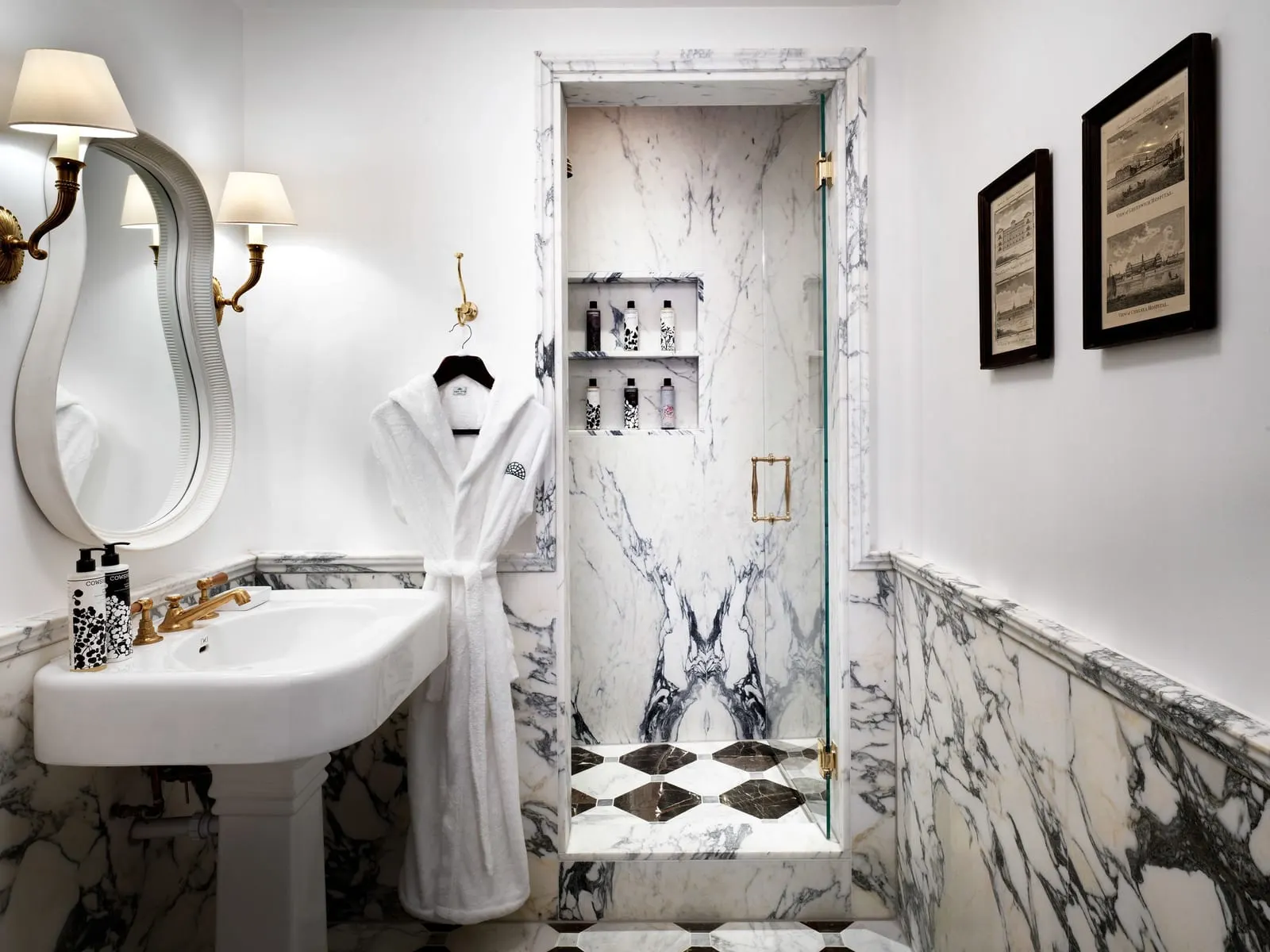 Heritage room bathroom at The Ned: a pedestal basin, a wavy mirror and a marble walk-in shower with a chequered floor