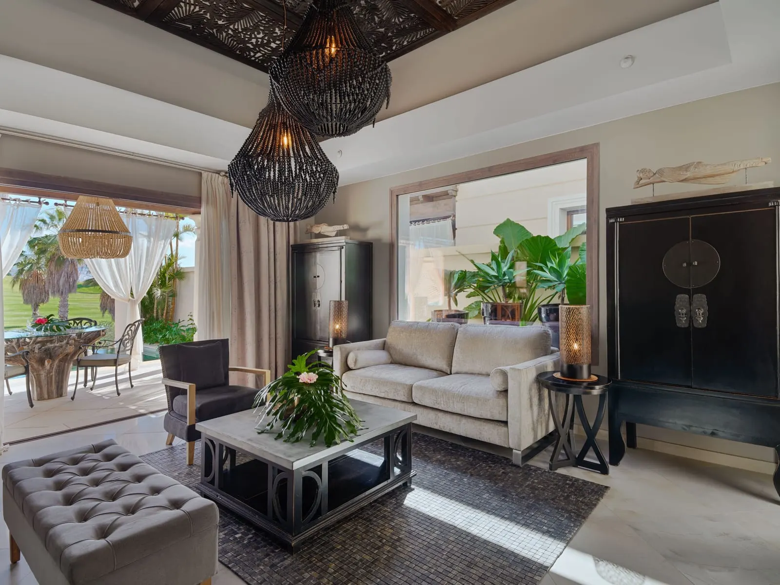 One-bedroom Grand Pool Villa at Royal River: the living room, with a sofa, a black cabinet and doors to a terrace