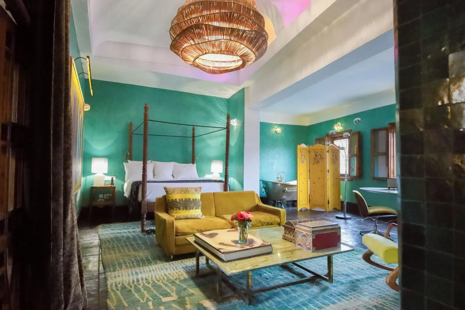 Two Bedroom Family Suite at El Fenn: a four-poster bed and a yellow sofa in a green room under a woven pendant lamp