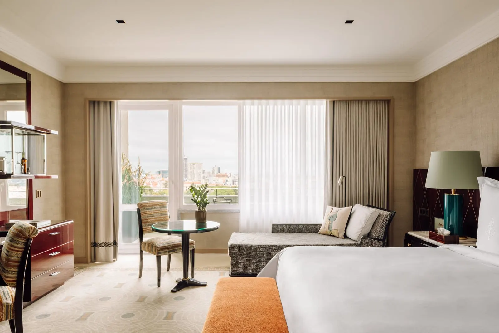 Deluxe Park-View Room at Four Seasons Ritz Lisbon: a daybed and a round table by glass doors onto the terrace