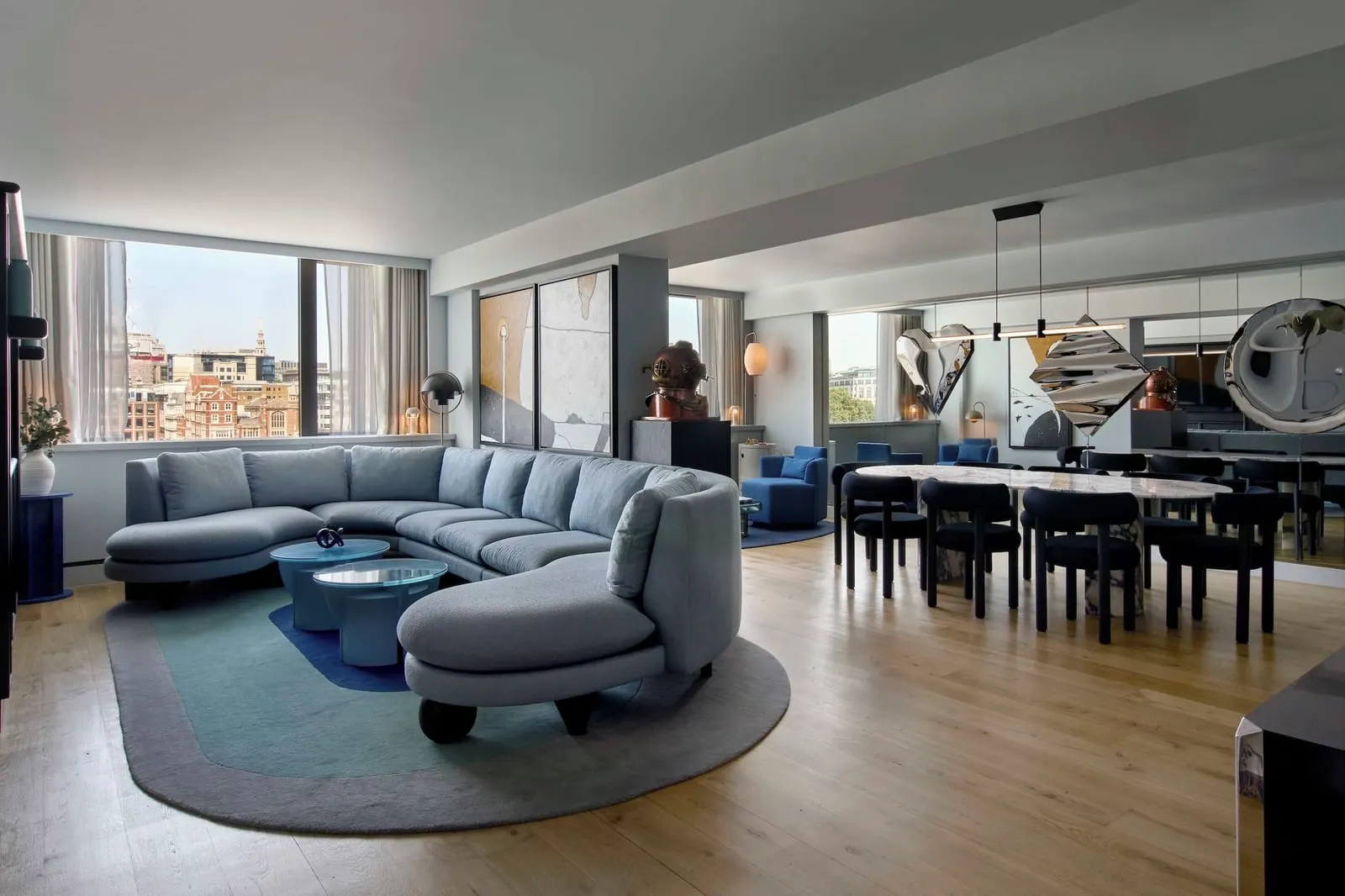 Thames Apartment at Sea Containers London: a curved blue sofa and a long dining table in one open-plan room