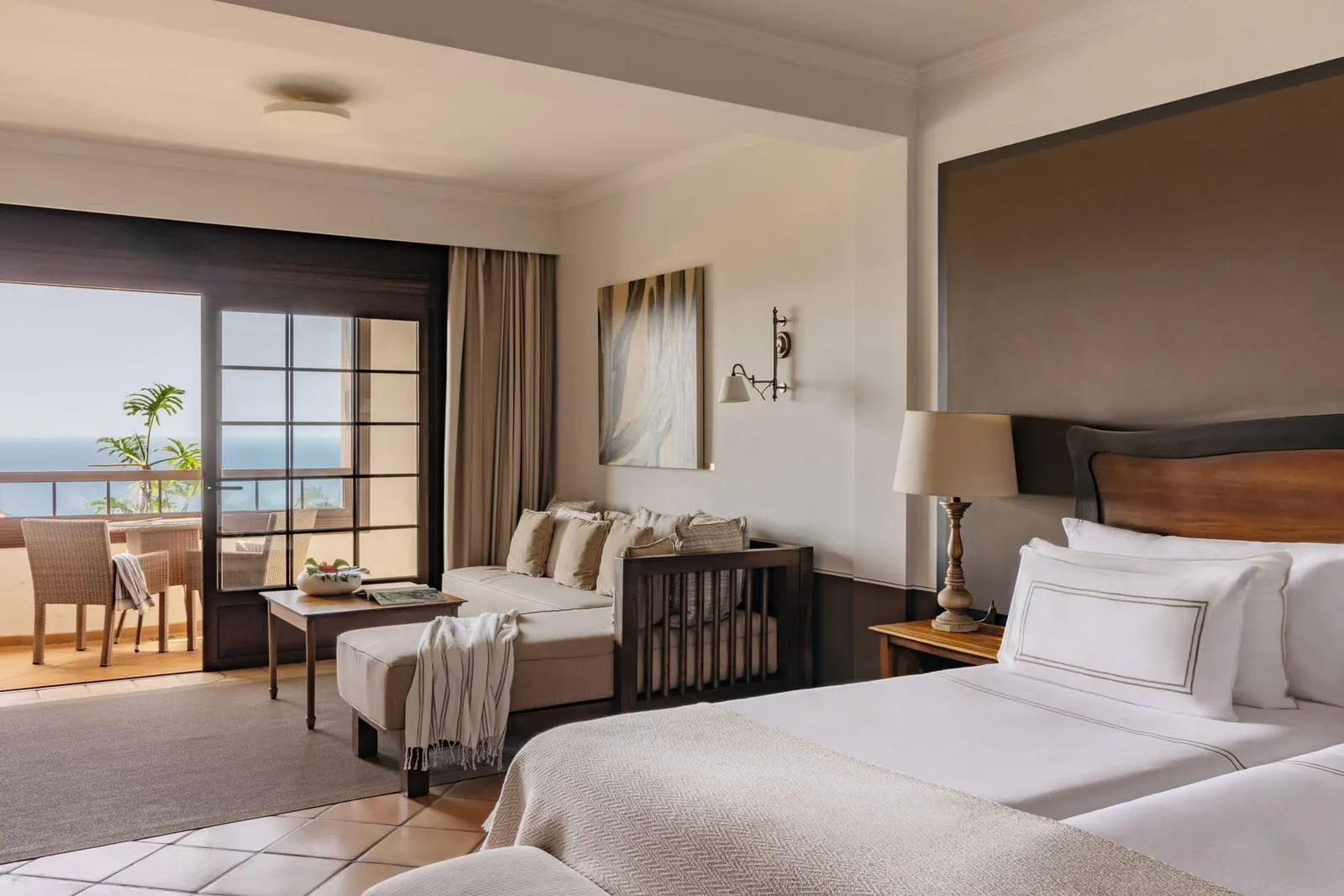 Singular Junior Suite Sea View at Hacienda del Conde: two beds, a sofa and doors to a balcony above the sea