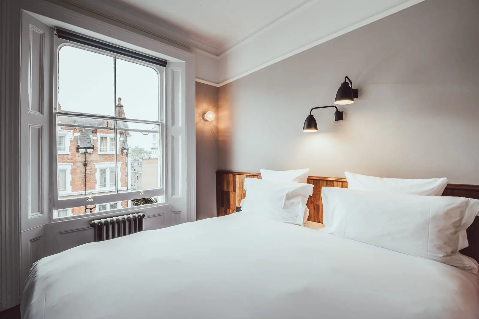 Comfy room at The Pilgrm: the bed beside a sash window looking onto red-brick houses