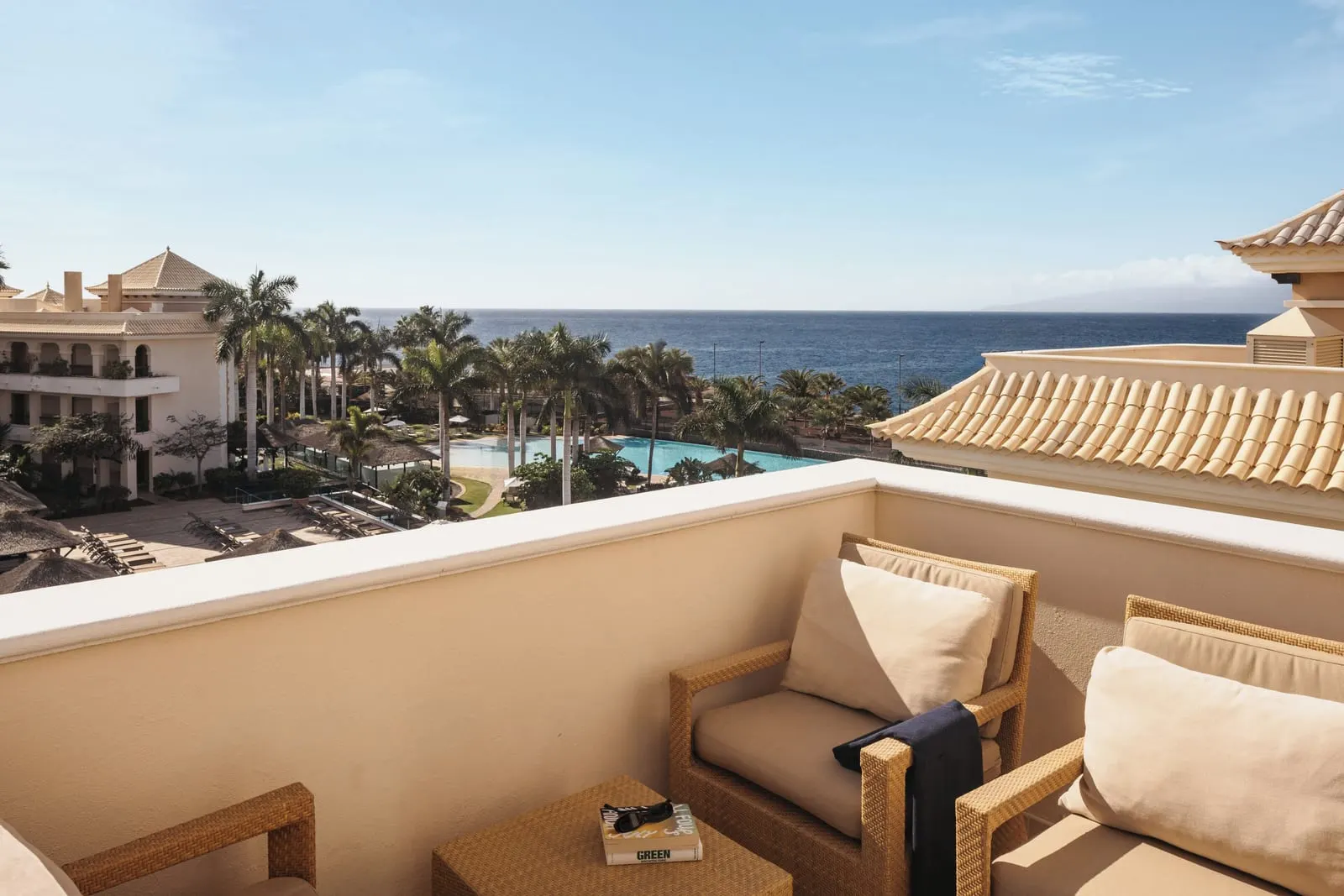 RedLevel Junior Suite Ocean Partial balcony at Gran Meliá Palacio de Isora: armchairs above pools, palms and the sea