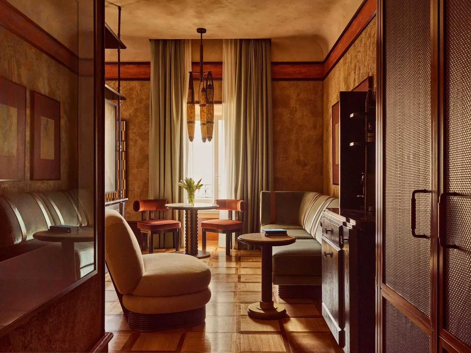 Junior Suite with View at Orient Express La Minerva: the sitting area with an armchair, a sofa and a table for two by the window