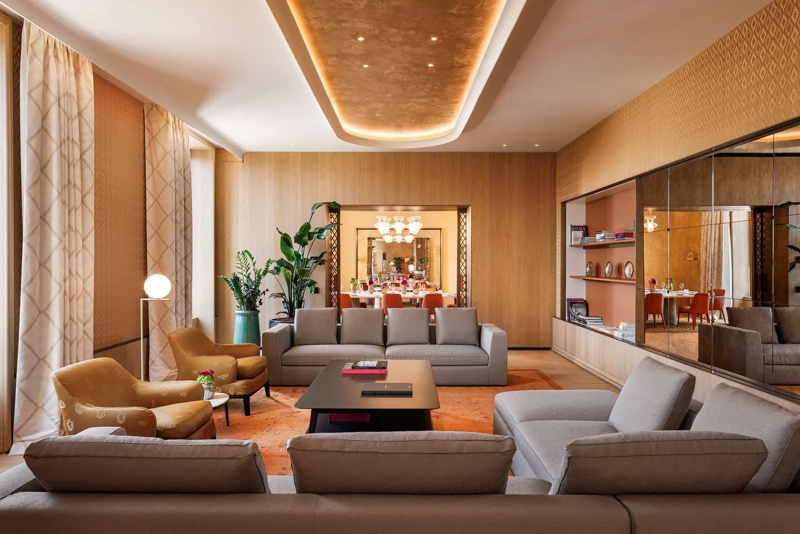 The Bvlgari Suite at Bvlgari Hotel Roma: the living room with sofas and armchairs, the dining room beyond
