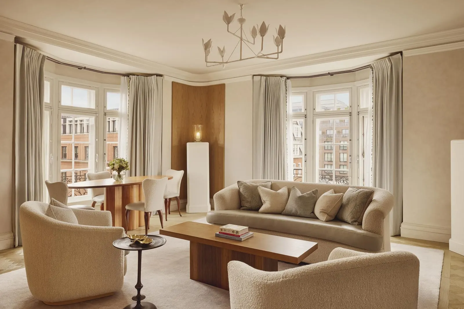 Claridge's Terrace Suite at Claridge's: the living room with a curved sofa, bay windows and a dining table