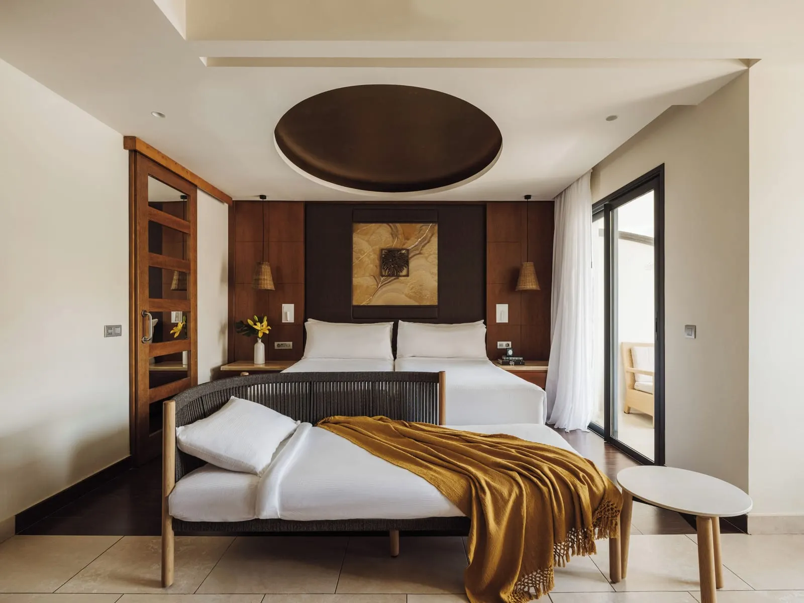 Deluxe Partial Ocean View at Gran Meliá Palacio de Isora: the bed with a gold throw, a daybed and the balcony door