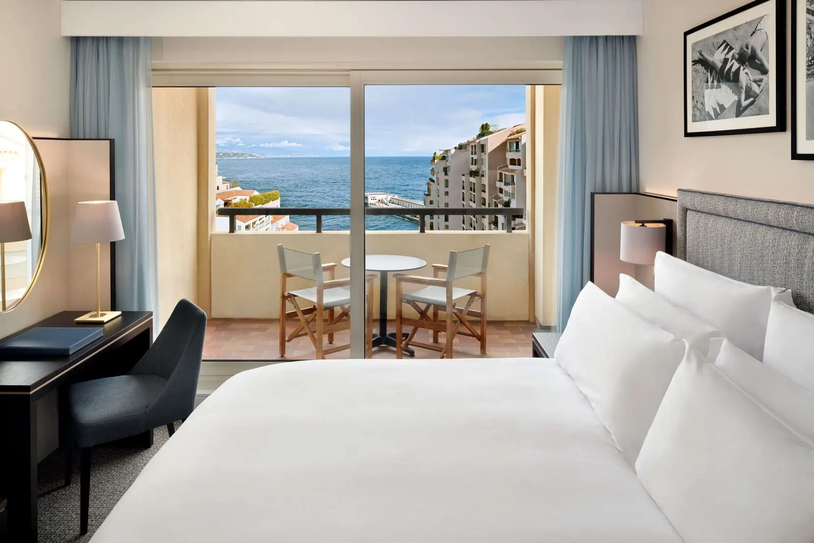 Riviera Deluxe Room at Columbus Hotel Monte-Carlo: the bed, a desk and glass doors to the terrace, with the sea beyond